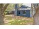 Back of home shows screened in porch and a textured exterior paint, with mature trees framing the view at 23067 Brighton Pl, Land O Lakes, FL 34639