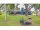 Expansive backyard featuring a fire pit, mature trees, and a view of the home's exterior at 23067 Brighton Pl, Land O Lakes, FL 34639