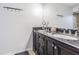 Bathroom featuring double sink vanity with black granite countertop and modern fixtures at 23067 Brighton Pl, Land O Lakes, FL 34639