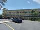 Condo building exterior with parking lot, palm trees and well maintained landscaping on a sunny day at 2459 Franciscan Dr # 29, Clearwater, FL 33763