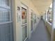 View of hallway of unit #29 with exterior doors, a floral wreath, and view of the parking lot at 2459 Franciscan Dr # 29, Clearwater, FL 33763