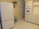 Kitchen with white appliances and tile flooring, alongside white painted cabinets and countertops at 2459 Franciscan Dr # 29, Clearwater, FL 33763