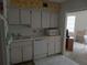 Kitchen featuring white appliances and cabinets with yellow wallpaper and access to a living area at 2459 Franciscan Dr # 29, Clearwater, FL 33763