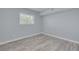 An empty bedroom with sleek gray floors, a window, and fresh white trim at 2525 W Bay Dr # A46, Largo, FL 33770
