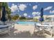 Community pool featuring several tables, lounge chairs, and umbrellas at 2525 W Bay Dr # A46, Largo, FL 33770