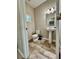 Half bathroom featuring a pedestal sink, tile floors, a window, and white fixtures at 2612 E 26Th Ave, Tampa, FL 33605