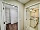 Hallway with doors to a bathroom with double vanity sinks and a walk-in closet with shelving at 2612 E 26Th Ave, Tampa, FL 33605