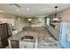 Open concept living area featuring wood-look tile floors, a fan, and an open staircase at 2612 E 26Th Ave, Tampa, FL 33605