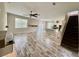 Open concept living area featuring wood-look tile floors, a fan, and an open staircase at 2612 E 26Th Ave, Tampa, FL 33605