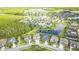 A grand aerial view shows a neighborhood of homes surrounding a pond and wooded area at 2812 Long Bow Way, Odessa, FL 33556