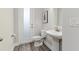 Stylish powder room with pedestal sink, decorative mirror, and frosted glass door at 2812 Long Bow Way, Odessa, FL 33556