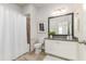 Bathroom features a shower/tub combo, vanity with granite counters, framed mirror, and white cabinets at 2812 Long Bow Way, Odessa, FL 33556