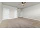 Bedroom with carpet, ceiling fan, and white doors leading to a bathroom and closet space at 2812 Long Bow Way, Odessa, FL 33556