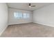 Spacious bedroom featuring neutral walls, a ceiling fan, two windows, and plush carpeting at 2812 Long Bow Way, Odessa, FL 33556