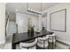 Open dining room area with a modern chandelier, stairs and wood-look floors at 2812 Long Bow Way, Odessa, FL 33556