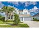 Traditional two-story home featuring a neutral color palette, a two-car garage, and palm trees at 2812 Long Bow Way, Odessa, FL 33556