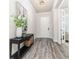 Inviting foyer with a decorative table, vase, and stylish gray wood-look floors at 2812 Long Bow Way, Odessa, FL 33556