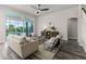 Spacious living room with large windows, stylish furnishings, ceiling fan, and views of the pool at 2812 Long Bow Way, Odessa, FL 33556