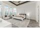 Serene main bedroom features large windows, a tray ceiling, and a sitting area at 2812 Long Bow Way, Odessa, FL 33556