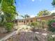 A beautiful backyard features a brick patio, tropical plants, and lush landscaping at 3354 52Nd N St, St Petersburg, FL 33703