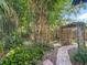 Lush backyard with tropical plants, bamboo, a wooden structure, and a brick pathway at 3354 52Nd N St, St Petersburg, FL 33703
