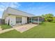 A nice backyard includes a lawn, concrete patio and screened-in patio area with a pool view at 3519 Richboro Dr, Holiday, FL 34691