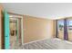 Bedroom with woodgrain floors and a bathroom en suite is brightened by a large window covered with full length curtains at 3519 Richboro Dr, Holiday, FL 34691