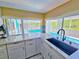 Modern kitchen featuring a sink with granite countertops and a view of the sparkling pool area outside at 3519 Richboro Dr, Holiday, FL 34691