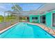 A beautiful screened-in pool is attached to a home with unique architecture and charm at 3519 Richboro Dr, Holiday, FL 34691
