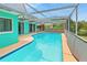 A bright turquoise pool surrounded by a screened in cage sits in the back yard of this home at 3519 Richboro Dr, Holiday, FL 34691