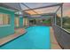 A bright turquoise pool surrounded by a screened in cage sits in the back yard of this home at 3519 Richboro Dr, Holiday, FL 34691