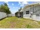 View of the home's backyard, featuring a screened-in porch and partial white fence at 358 Highland Shores Dr, Ellenton, FL 34222