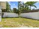 Fenced backyard with grass and partial views of the surrounding trees at 358 Highland Shores Dr, Ellenton, FL 34222