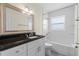 Bathroom featuring a tub and shower, vanity with black counter top, and a large mirror with lighting at 358 Highland Shores Dr, Ellenton, FL 34222