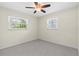 Bedroom with carpet flooring, cream walls, two windows with blinds, and a ceiling fan with light at 358 Highland Shores Dr, Ellenton, FL 34222