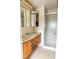 Bathroom with a vanity with wood cabinets, a sink and a mirror and a glassed in shower at 37302 Carol Ave, Zephyrhills, FL 33542