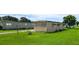 Rear exterior view of home situated on a green lawn showing the home's siding and outdoor space at 37302 Carol Ave, Zephyrhills, FL 33542