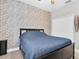 Bedroom featuring a stylish accent brick wall, modern ceiling fan, and plank skateboard art at 3800 Night Star, Odessa, FL 33556