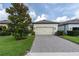 Exterior showcasing a two-car garage, meticulously maintained lawn, and elegant paver driveway at 3800 Night Star, Odessa, FL 33556