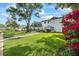 Expansive backyard with lush green grass, mature trees, waterfront access, and a patio, perfect for outdoor enjoyment at 3956 Versailles Dr, Tampa, FL 33634