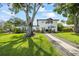 Spacious backyard featuring a large tree providing ample shade, a manicured lawn, and a white two-story house at 3956 Versailles Dr, Tampa, FL 33634