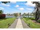Waterfront home featuring a dock and a path leading to the house, surrounded by lush landscaping and blue skies at 3956 Versailles Dr, Tampa, FL 33634