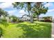 Sprawling backyard featuring lush green lawn, mature trees and outdoor seating area, perfect for entertaining guests at 3956 Versailles Dr, Tampa, FL 33634