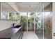 Bathroom with garden view from glass shower, sleek vanity, and modern mirror at 3956 Versailles Dr, Tampa, FL 33634