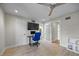 A bright room with a ceiling fan featuring a desk, large screen TV, and frosted glass door at 3956 Versailles Dr, Tampa, FL 33634