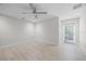 Bright bedroom featuring light wood floors, a ceiling fan, and sliding glass door at 3956 Versailles Dr, Tampa, FL 33634