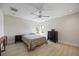 Minimalist bedroom with hardwood floors, ceiling fan, dresser, and two windows at 3956 Versailles Dr, Tampa, FL 33634