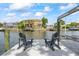 Waterfront dock with comfortable chairs, boat lift, and stunning views of a beautifully landscaped waterfront home at 3956 Versailles Dr, Tampa, FL 33634