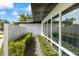 Modern home exterior with clean lines, large windows reflecting lush greenery, complemented by manicured landscaping at 3956 Versailles Dr, Tampa, FL 33634