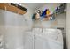 Bright laundry room with side by side washer and dryer, shelving, and organized space at 3956 Versailles Dr, Tampa, FL 33634